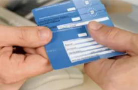An insurance card being handed to someone.